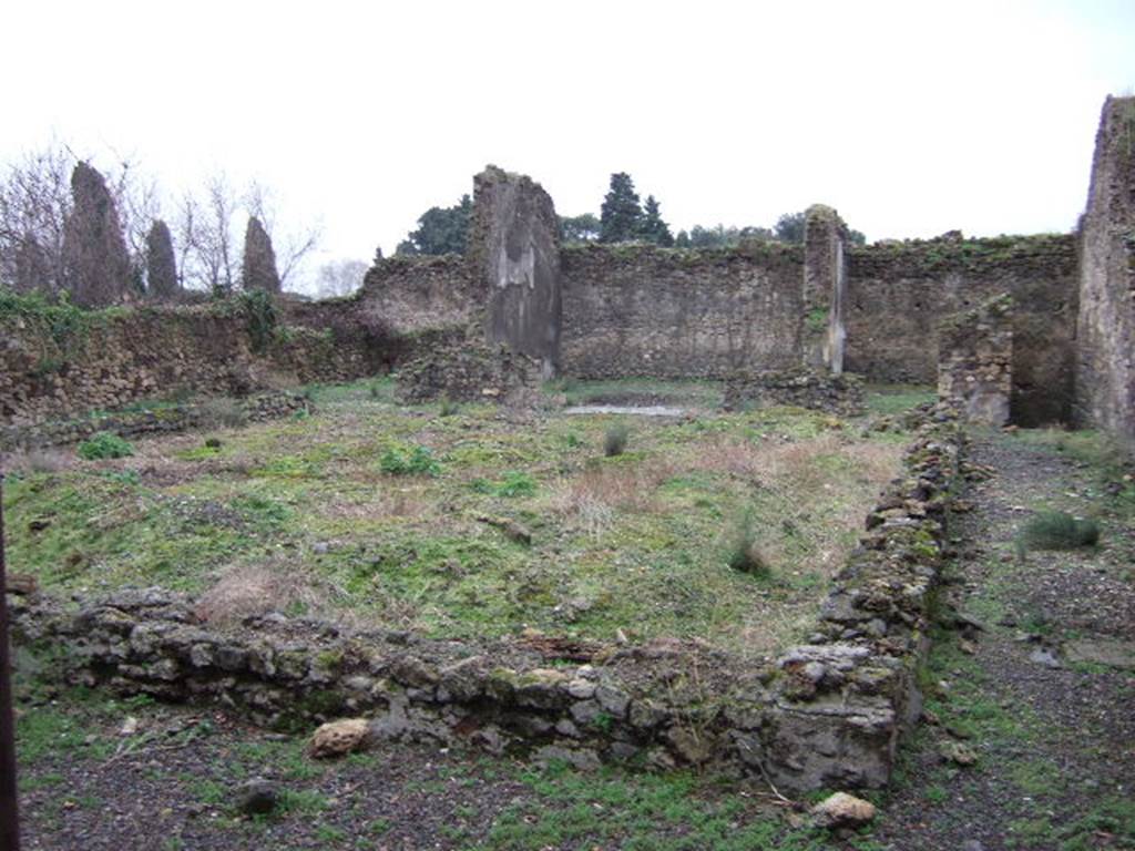 VII.11.6 Pompeii. December 2005.  Garden area looking south towards exedra in centre of south wall. December 2005. According to Helbig, found in the middle room behind the peristyle was a painting of Oreste and Pilades at Tauris.
See Helbig, W., 1868. Wandgemälde der vom Vesuv verschütteten Städte Campaniens. Leipzig: Breitkopf und Härtel. (1335)
According to Jashemski, this once fine house, converted into a hospitium after the earthquake, at one time had a large peristyle garden.
It had a portico on all four sides. The columns were joined by a low wall which enclosed the garden, leaving one entrance to the garden on the north, and two on the south. A cistern opening was enclosed in the low wall on the north.  Only a few stumps of the columns are preserved.  
There was a gutter around the edges of the garden.
See Jashemski, W. F., 1993. The Gardens of Pompeii, Volume II: Appendices. New York: Caratzas. (p.192)
