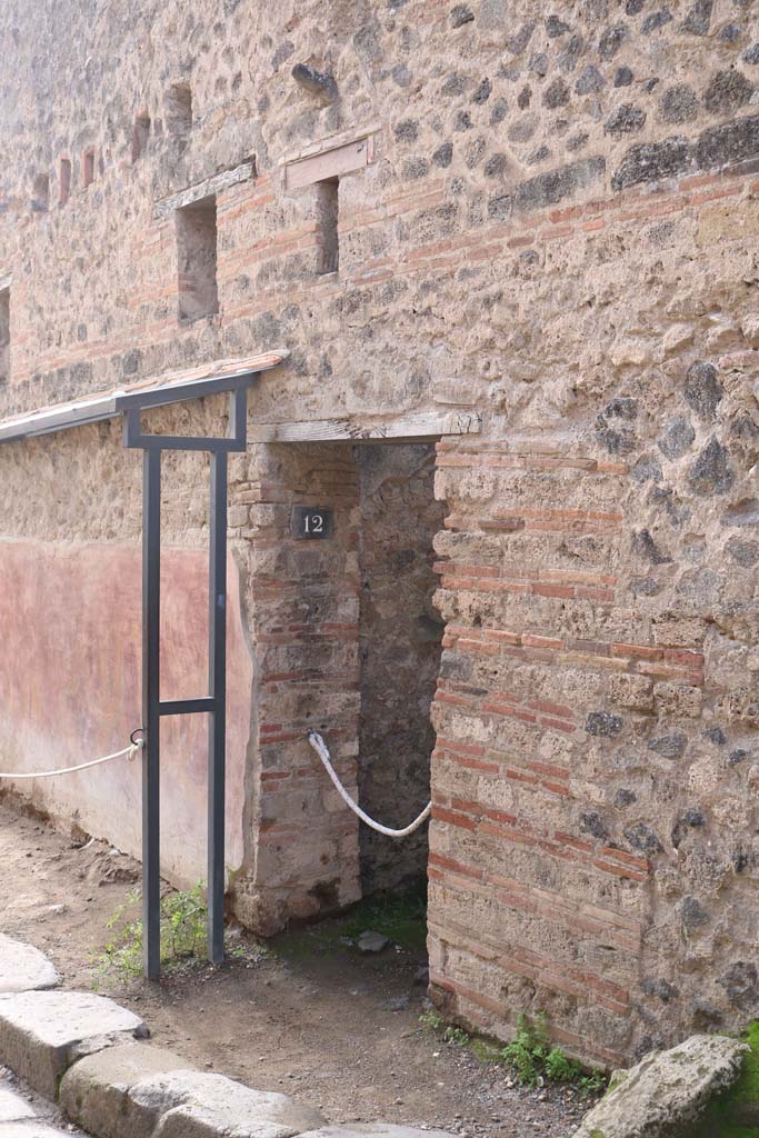 VII.11.12, Pompeii. December 2018. 
Phallus on outside wall above small window above doorway. Photo courtesy of Aude Durand.
