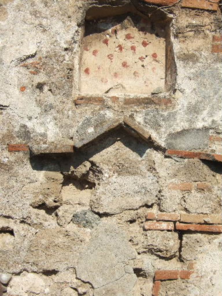 VII.12.13 Pompeii. September 2005. Niche on east wall near oven.
According to Boyce, on the wall of the room with the oven, near the hearth, was a lararium painting. Into the panel, near the top, was set a rectangular niche with projecting floor. The inside walls were coated with white stucco decorated with spots of many colours. On the wall on each side of it were the traces of the figure of a Lar. Below the niche a pediment was formed by bricks embedded in the wall. Within the pediment were painted a cock and a peacock, one above the other.
On the wall below the pediment were painted two serpents confronted at an altar. At the side of the altar stood Vesta, wearing a wreath of flowers. At her side stood an ass, its head appearing above the altar.
See Boyce G. K., 1937. Corpus of the Lararia of Pompeii. Rome: MAAR 14. (p.71, no.318) 
