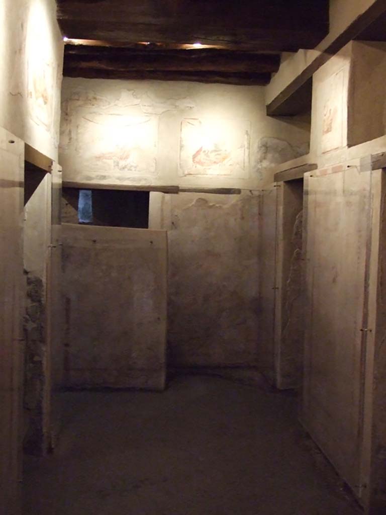 VII.12.18 Pompeii. December 2006. The latrine is behind screen wall at far end.
The central corridor has five prostitutes’ rooms arranged on both sides.
Paintings showing various sexual positions are on the wall above the rooms.

