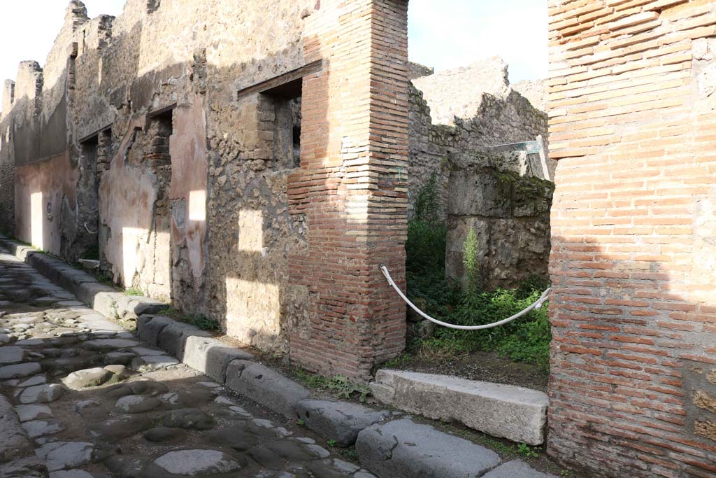 VII.12.21 Pompeii on right. December 2018. 
Looking towards entrance doorway on north side of Vicolo del Balcone Pensile. Photo courtesy of Aude Durand.

