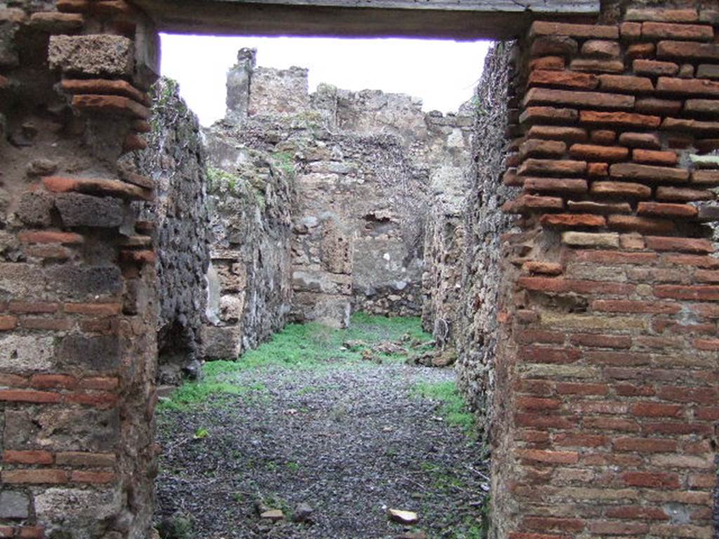 VII.12.31 Pompeii. Looking north through doorway to corridor. This used to contain steps to the upper floor, with a latrine underneath. Ahead at the rear was a cubiculum. On the left, a doorway leading to VII.12.32, on the right a doorway leading to VII.12.30. 
