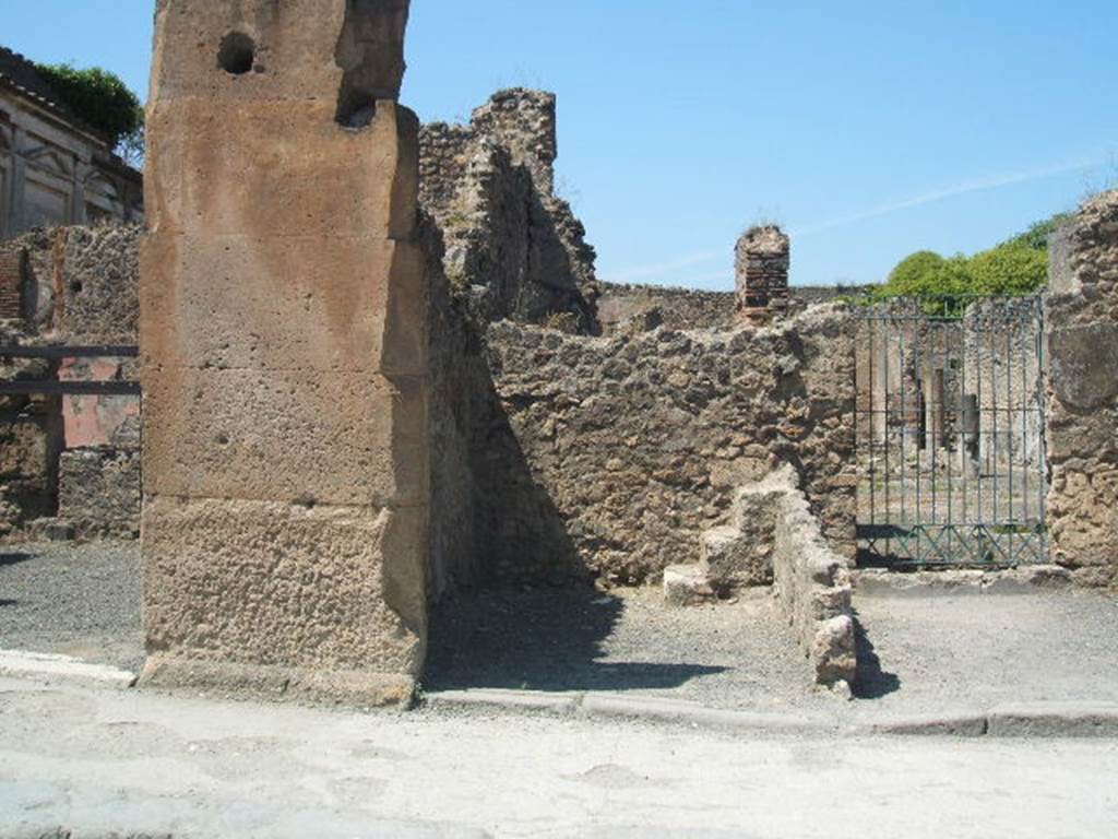 VII.13.1/2/3 Pompeii. May 2005. Looking north to doorway to VII.13.2, in the centre. At the rear on the right, can be seen the steps to the upper floor.
