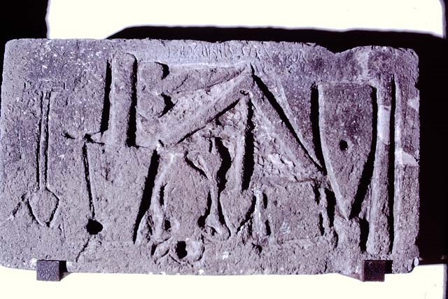 VII.15.1/2 Pompeii. February 2021. 
Limestone relief signed by the master builder (structor) Diogenes depicting –
a trowel, an apotropaic phallus, a plumbline, a cudgel or an axe/a hammer that cuts orthogonally, a scalpel and two unidentifiable objects. 
On display in Antiquarium at VIII.1.4 but found on the west perimeter wall of the house at VII.1.52, on Via dei Soprastanti.
Photo courtesy of Fabien Bièvre-Perrin (CC BY-NC-SA).
