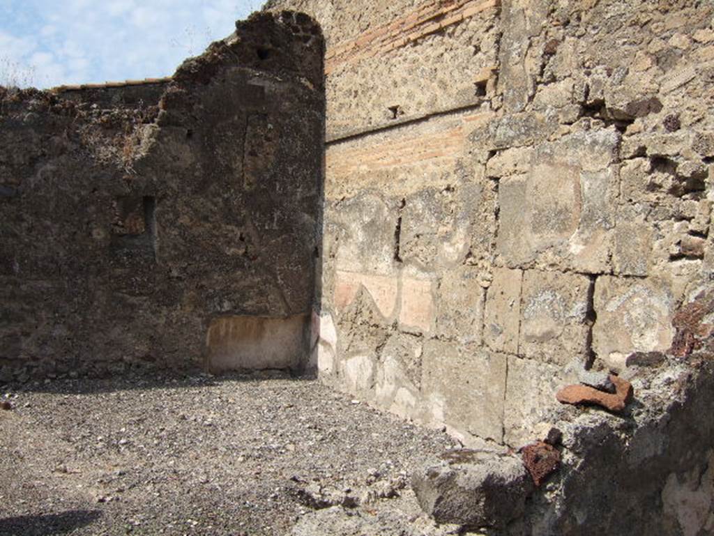VII.15.9 Pompeii. September 2005. Looking towards the north-west corner of the triclinium, the largest room of the house with white painted stucco above a yellow zoccolo on the walls. A window in the west wall opened towards the courtyard at the rear of house VII.15.13.


