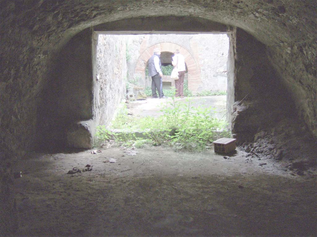 VII.15.16 Pompeii. May 2006. Looking across room (L) towards unroofed courtyard of bakery.
The small doorway through to storerooms T, V, W, X, Y and Z, is in the south wall of room L, on the right.  

