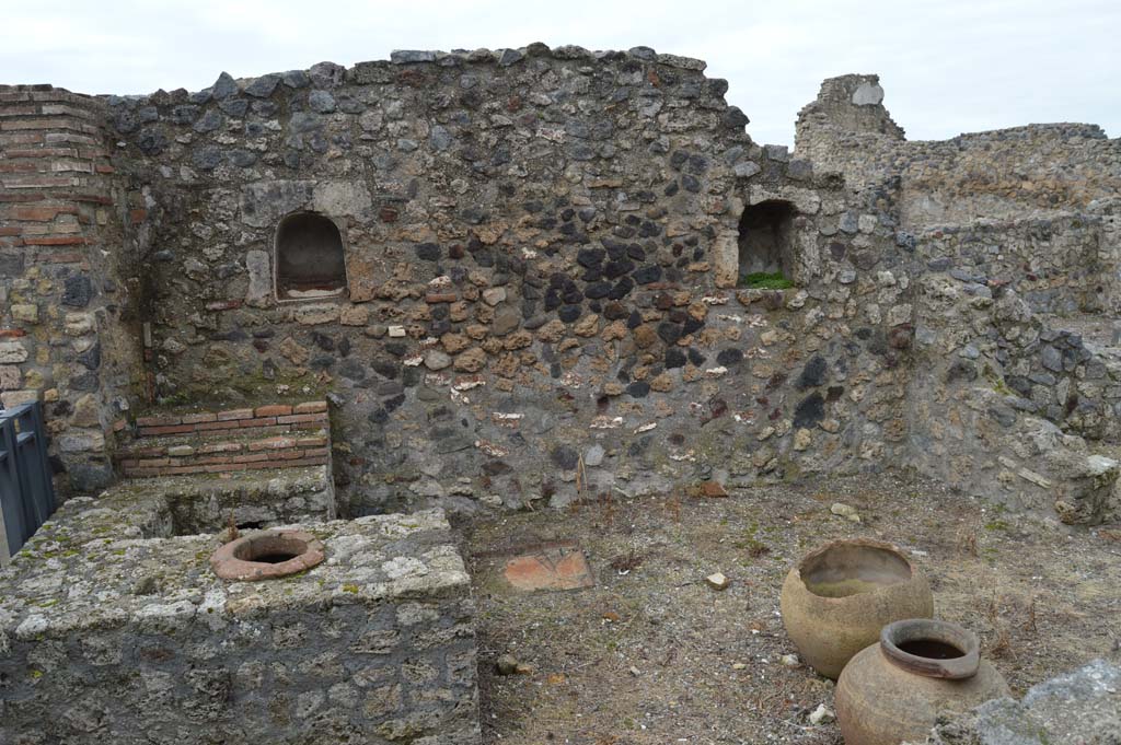 VII.16.7 Pompeii. December 2018.  
Looking west towards entrance doorway, on left, counter with display shelves and inset urn/s, and west wall with two niches.
Photo courtesy of Aude Durand.
