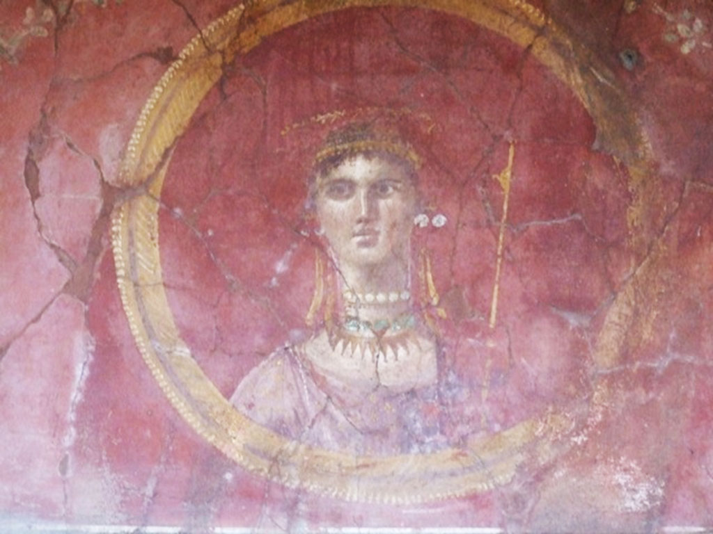 VII.16.17-22 Pompeii. December 2007. 
Room 7, room overlooking portico (2) in House of Maius Castricius, detail of painted face of female divinity in round panel.
According to Varriale, this is a painted shield with painting of Venus Physica Pompeiana.
See Varriale I., VII 16, Insula Occidentalis, 17, Casa di Maius Castricius in Aoyagi M., Pappalardo U., 2006. Pompei (Regiones VI-VII) Insula Occidentalis. Napoli: Valtrend, p 442.
