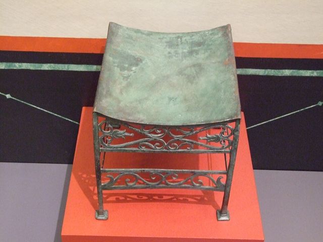 VII.16.17-22, Pompeii. May 2018. Bronze stool decorated with palms and lotus flowers. Parco Archeologico di Pompei, inventory number 13355.
Pot (olla) in bronze for the boiling of foods, Parco Archeologico di Pompei, inventory number 14069.  
Photo courtesy of Buzz Ferebee.
