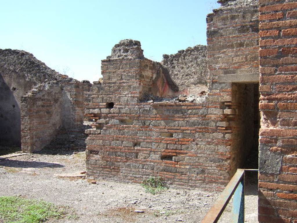 VIII.2.30 Pompeii. September 2005. North-west corner of atrium, with doorway to cubiculum, on left. The doorway is on the south wall of the open recess leading to the steps to VIII.2.29. On the right can be seen the doorway to the corridor leading to kitchen, and VIII.2.29.
