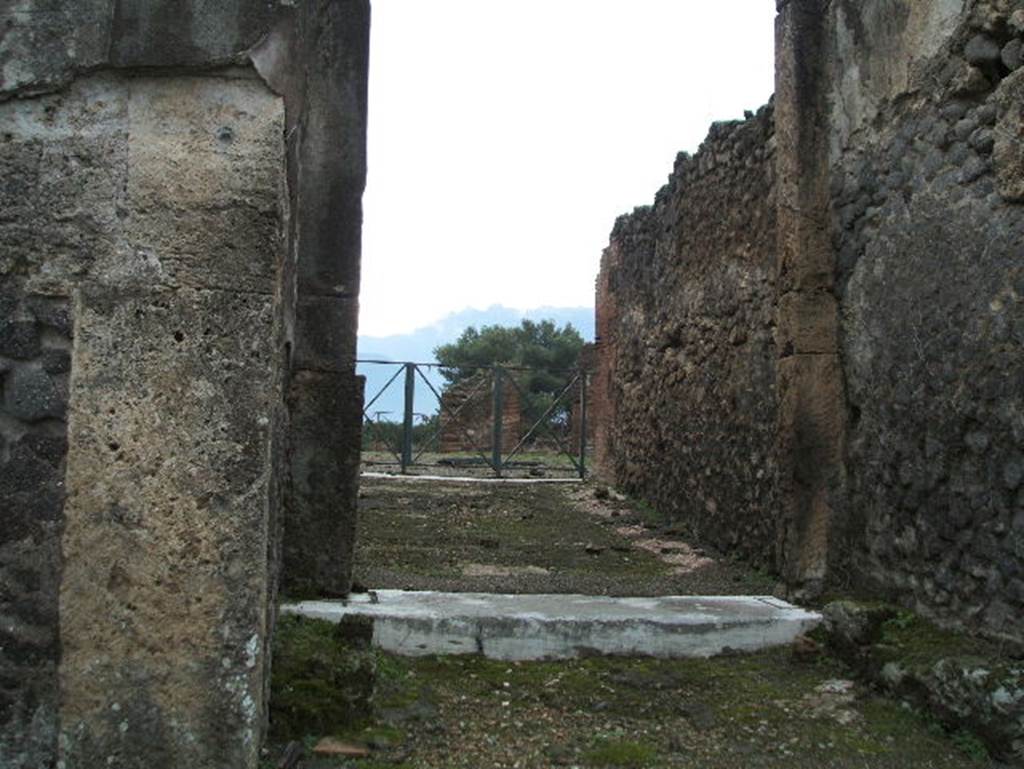 VIII.2.34 Pompeii. May 2006. Looking south from entrance fauces or corridor, towards atrium.
According to Mau, the floor of the entrance corridor was separated from the atrium flooring by a threshold of white marble with some dark veining; 
at its ends you could see the holes for the door hinges. 
There were no bolts; so, to fasten the door closed there were no other means than to unite the two shutters, either with a lock or some other way.
See Mau, Bullettino dell’Instituto di Corrispondenza Archeologica (DAIR), 1886, (p.149).
