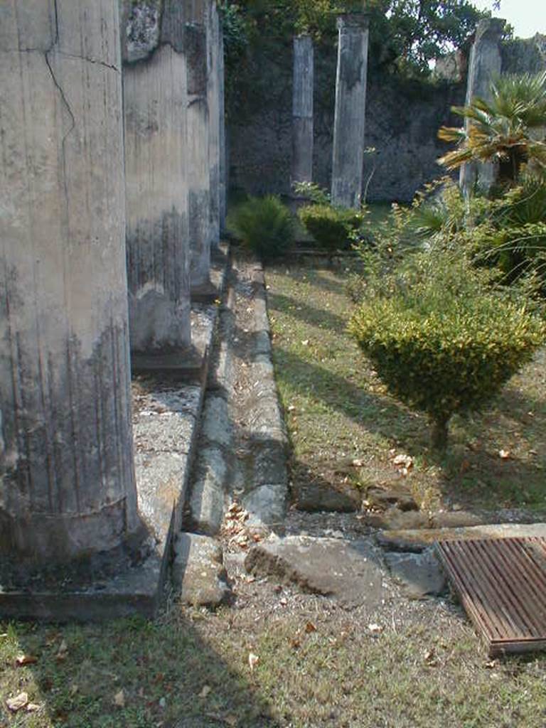 VIII.3.8 Pompeii. September 2004.  Looking south across peristyle, showing drainage channel for rainwater from roof of portico. 
