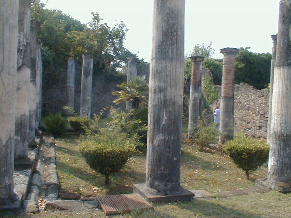 VIII.3.8 Pompeii. September 2004. Peristyle, looking south towards the large exedra.
According to Breton -  "two columns  were placed on pedestals decorating the entrance to the oecus, where the mosaic paving had only conserved some remains of the beautiful greek white, black, red and yellow which surrounded it.”
 See Breton, Ernest. 1870. Pompeia, Guide de visite a Pompei, 3rd ed. Paris, Guerin, (p.453)
