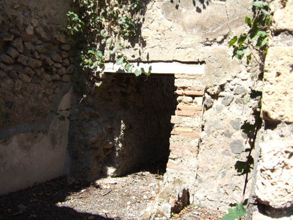 VIII.3.13 Pompeii. September 2005. Looking north from entrance into kitchen, with doorway in north wall to a small room or storeroom. The area in the north-east corner, with the remains of the small wall, may be the site of the latrine.
