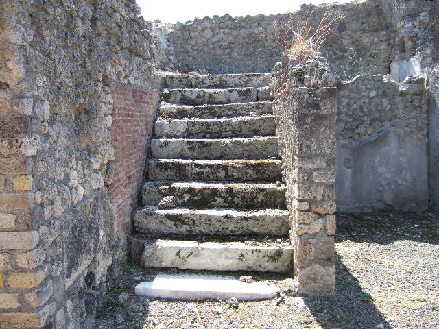 VIII.3.14 Pompeii. September 2005. Steps to upper floor in south-east corner of atrium. On the extreme left is the doorway to the kitchen, latrine and small storeroom.
