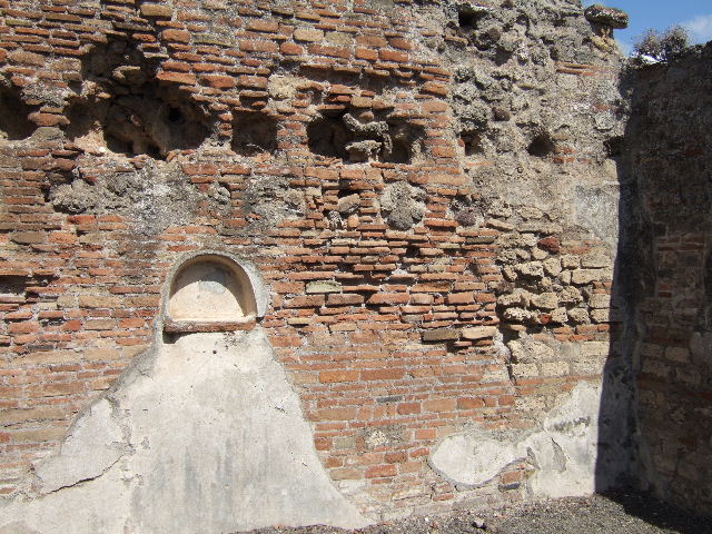 VIII.3.14 Pompeii. September 2005. North wall of kitchen with niche.
According to Boyce, in the north wall was an arched niche. Its floor was a projecting tile, its walls were coated with white stucco outlined with red stripes.  See Boyce G. K., 1937. Corpus of the Lararia of Pompeii. Rome: MAAR 14. (p.75, no.353) 
