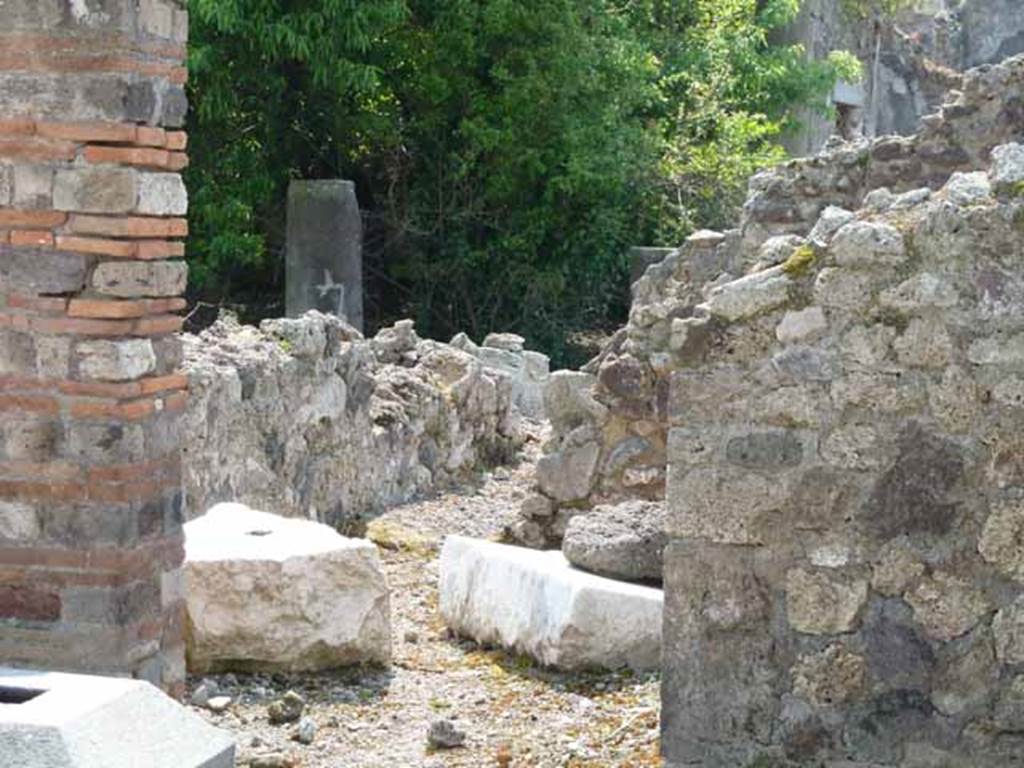 VIII.3.31 Pompeii. May 2010. Doorway on south side of atrium to small or storeroom. Looking across remains of wall towards the peristyle area.