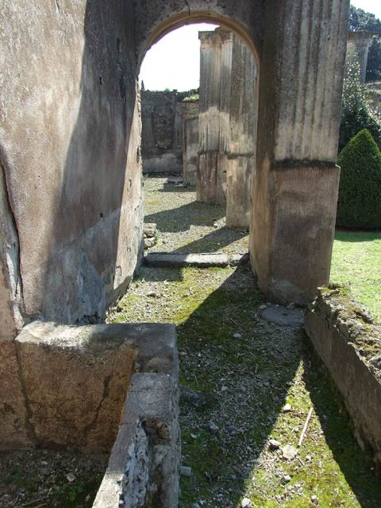 VIII.4.4 Pompeii.  March 2009.  Room 8.  Corridor on west side of kitchen, with basin. Looking south to east portico.