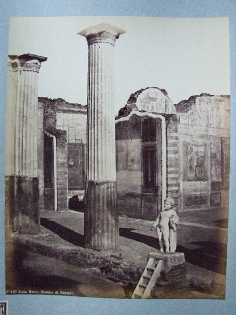 VIII.4.4 Pompeii. Fountain and south portico of peristyle. Old undated photograph.
Courtesy of Society of Antiquaries, Fox Collection.
According to Dyer:
“Two of the rooms on the further side of the peristyle, and at the extremity of the house, are visible in this view.
The smaller one, on the left, appears to be a bedchamber.
The floor is of opus Signinum; the walls painted mostly red and yellow, apart from the usual architectural ornaments, also have pictures of Nereids riding through the waves on sea-monsters.
The picture facing the entrance, so far as can be made out, represented the Dioscuri.
Next to this room, on the right, is a large and handsome exedra, or retiring room.
It is paved with black and white marble, and has in its middle a small impluvium or basin; from which we may infer that there was a corresponding aperture in the roof.
The walls were adorned with small but well-executed pictures.
On the facing wall was Narcissus admiring himself in the fountain.
On the left wall a Hermaphrodite leaning on the shoulder of Silenus could be seen.
On the right wall, Bacchus accompanied by his usual troop, discovering Ariadne. 
See Dyer, Thomas, 1867: The Ruins of Pompeii. London: Bell and Daldy, (p.80).


