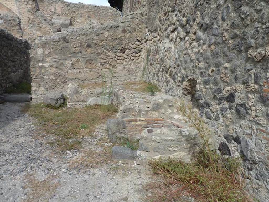 VIII.4.35 Pompeii, September 2015. North-east corner of shop. Remains of two-sided podium or counter with a furnace and tub.
