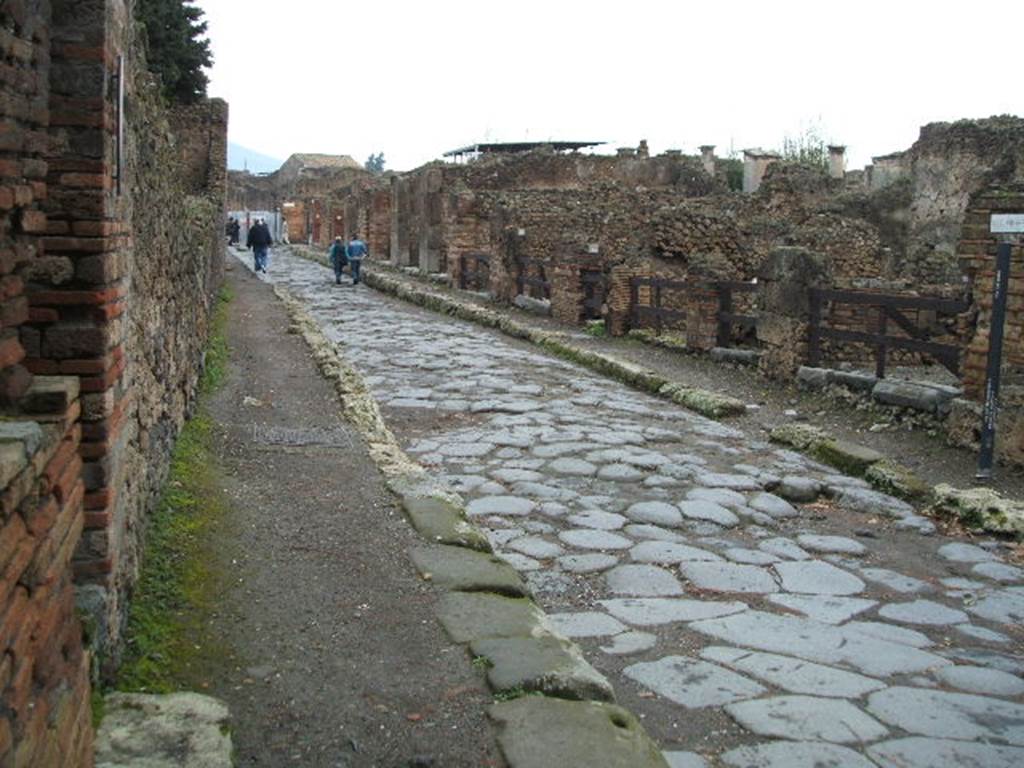 VIII.5 Pompeii, on left. December 2004. Via dei Teatri looking north. VIII.4.40 on corner, on right.looking north. VIII.4.40 on corner.