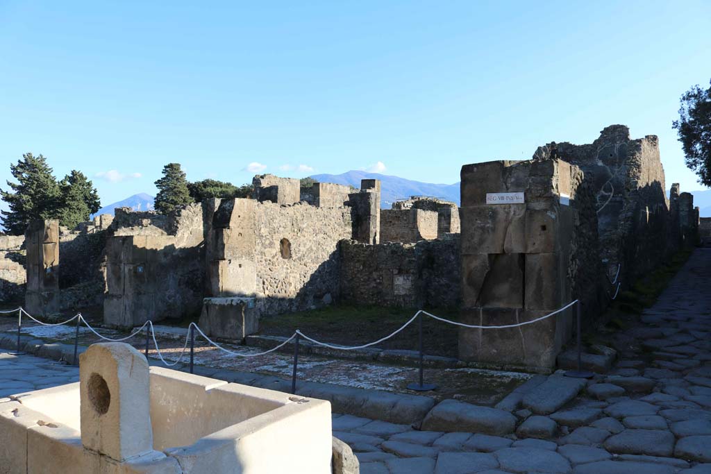 VIII.5.1 Pompeii. December 2018. 
Looking south from behind fountain at VII.9.67 towards entrance doorway on east side of junction with Vicolo dei dodici Dei, on right.
Photo courtesy of Aude Durand.

