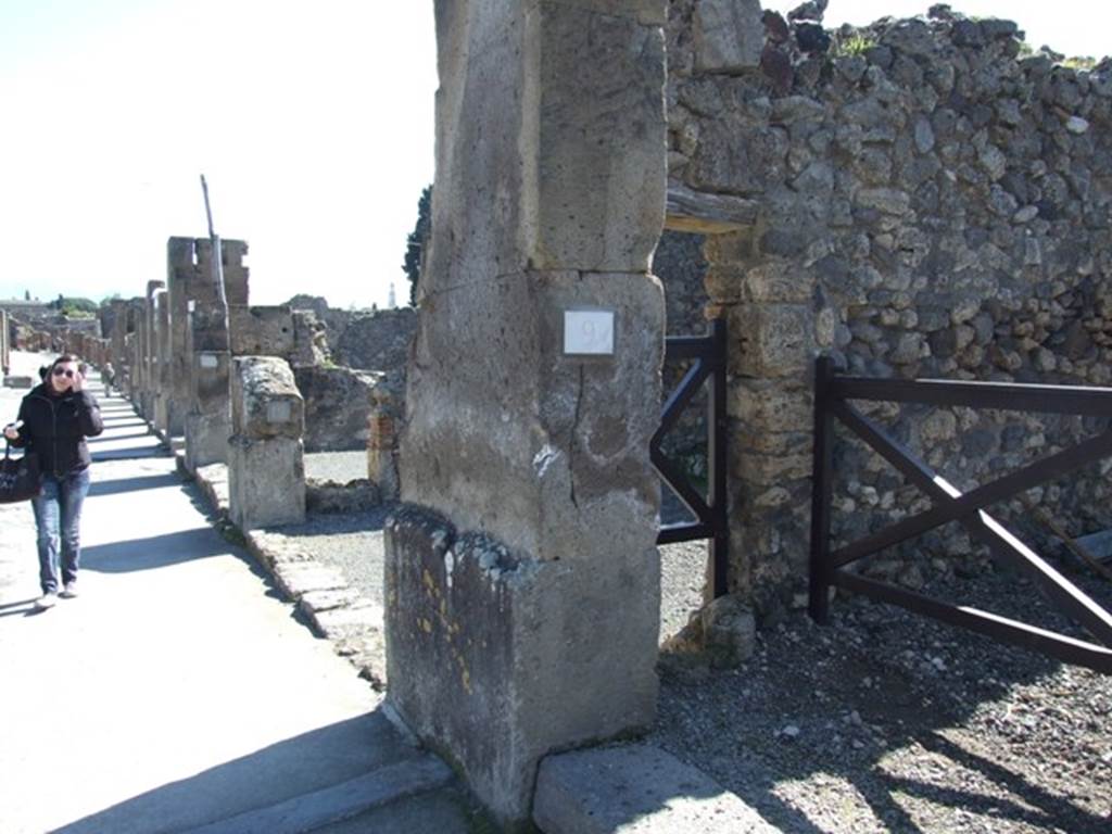 VIII.5.9 Pompeii. March 2009. East side of entrance fauces on Via dell’Abbondanza, with puteal for a well in small doorway to shop at VIII.5.10
According to Maiuri, 
“This house also opened onto the south side of the Via dell’Abbondanza, with a doorway in tufo between two shops; it had a short but wide entrance corridor with undecorated walls in large part restored after the earthquake; a stone threshold was on the external side of the doorway and one of travertine on the interior between the corridor and the atrium; a puteal for a well was embedded in the left wall, where it would have been used above all by the neighbouring shop (another puteal was inserted in the dividing wall between the shops numbered 10 and 11.”
see Maiuri in Notizie degli Scavi, 1944-45, (p.154). 
shop at VIII.5.10