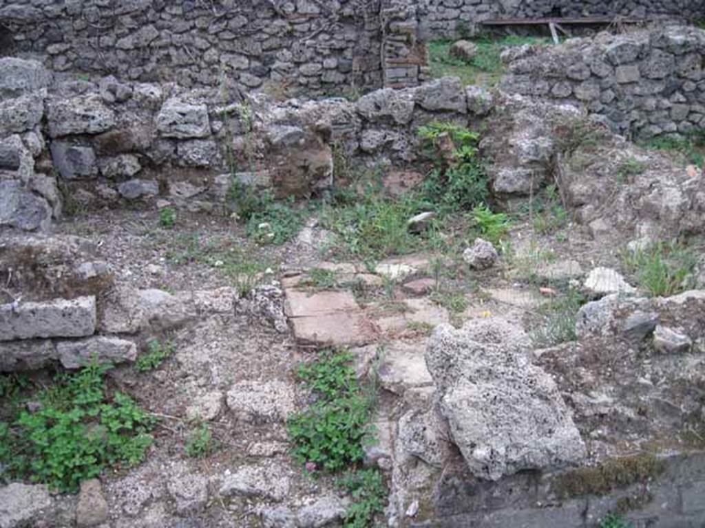 VIII.7.12 Pompeii. September 2010. Remains of kitchen area, the third room south of corridor, with feature of raised platform with tiled top. Photo courtesy of Drew Baker.
