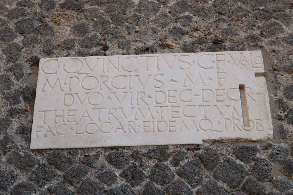 VIII.7.21 Pompeii. September 2005. Second dedication plaque on wall by the entrance from the large theatre.
C QVINCTIVS C F VALG
M PORCIVS M F
DVO VIR DEC DECR
THEATRVM TECTVM
FAC LOC AR EIDEMQ PROB    [CIL X 844b]
 
C(aius) Quinctius C(ai) f(ilius) Valg(us) 
M(arcus) Porcius M(arci) f(ilius)
duovir(i) dec(urionum) decr(eto)
theatrum tectum 
fac(iundum) locar(unt) eidemq(ue) prob(arunt)    [CIL X 844b]
 
Gaius Quinctius Valgus, son of Gaius, and Marcus Porcius, son of Marcus, duumvirs, by decree of the town councillors awarded the contract for the construction of the covered theatre and also approved it.
See Cooley, A. and M.G.L., 2004. Pompeii: A Sourcebook. London: Routledge. (p.20, B9). CIL X 844=ILS 5636.
 
A Theatrum Tectum was a covered theatre; in this case it refers to the Small Theatre or Odeon in Pompeii.
