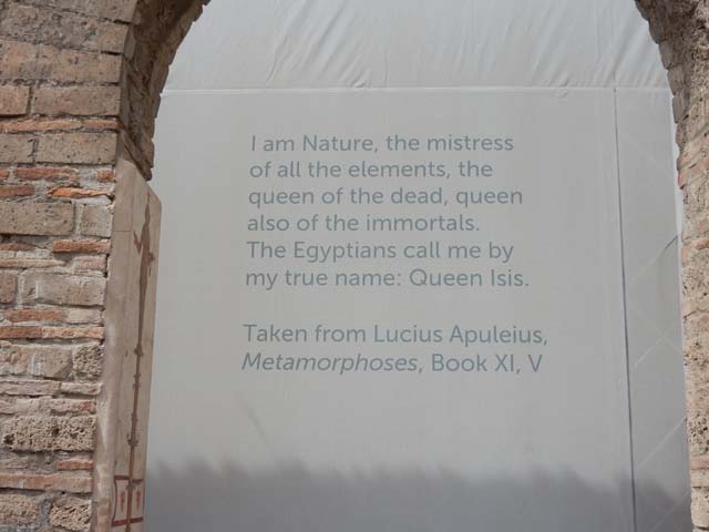 VIII.7.28 Pompeii. May 2017. Display screen with quotation, behind an arch of the Ekklesiasterion.
“I am nature, the mistress of all the elements, the queen of the dead, queen also of the immortals. The Egyptians call me by my true name: Queen Isis.”
From Lucius Apuleius, Metamorphoses, Book XI, V.
Photo courtesy of Buzz Ferebee.
