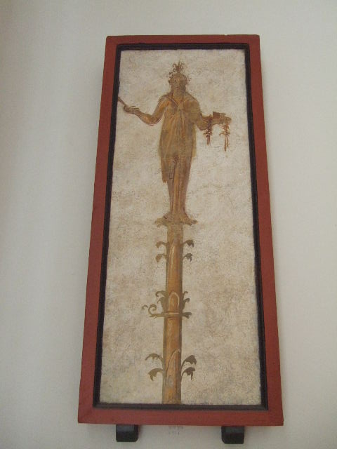 VIII.7.28 Pompeii.  Priestess on a candelabrum carrying offerings on a tray.  
Found in passageway of arch.  Now in Naples Archaeological Museum.
