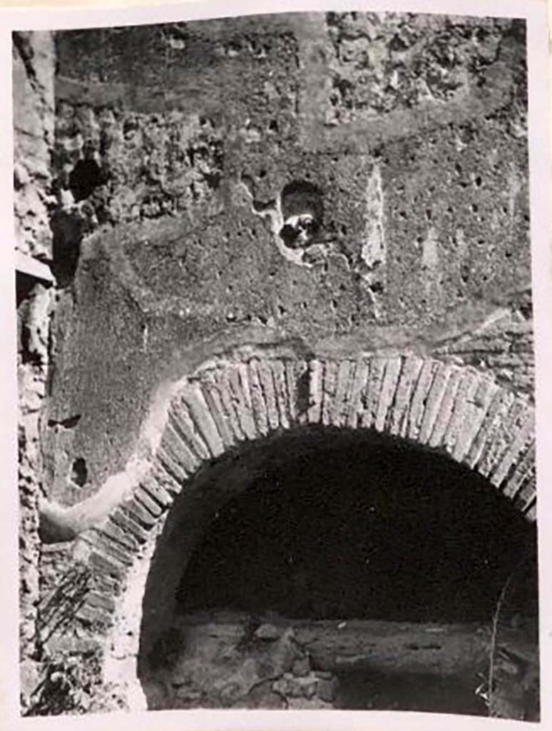 IX.1.3/ IX.1.33. Pre-1943. Brickwork and decorative plaque above oven. Photo by Tatiana Warscher.
According to Warscher 
Above the opening of the oven, above the brickwork with the phallus, a terracotta head was embedded. 
If I am not mistaken, no-one has mentioned this.  
A. Mau cited a similar head on the hearth of the house at I.3.8, found in 1870.
Unfortunately, the head seen by Mau has gone. 
See Warscher, T. Codex Topographicus Pompeianus, IX.1. (1943), Swedish Institute, Rome. (no.12a), p. 23.
