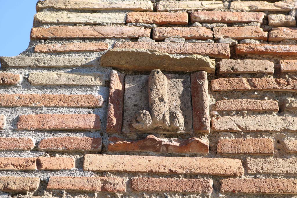 IX.1.13, and IX.1.14, Pompeii. December 2018. 
Detail of tufa phallus set into pilaster between entrances. Photo courtesy of Aude Durand.
