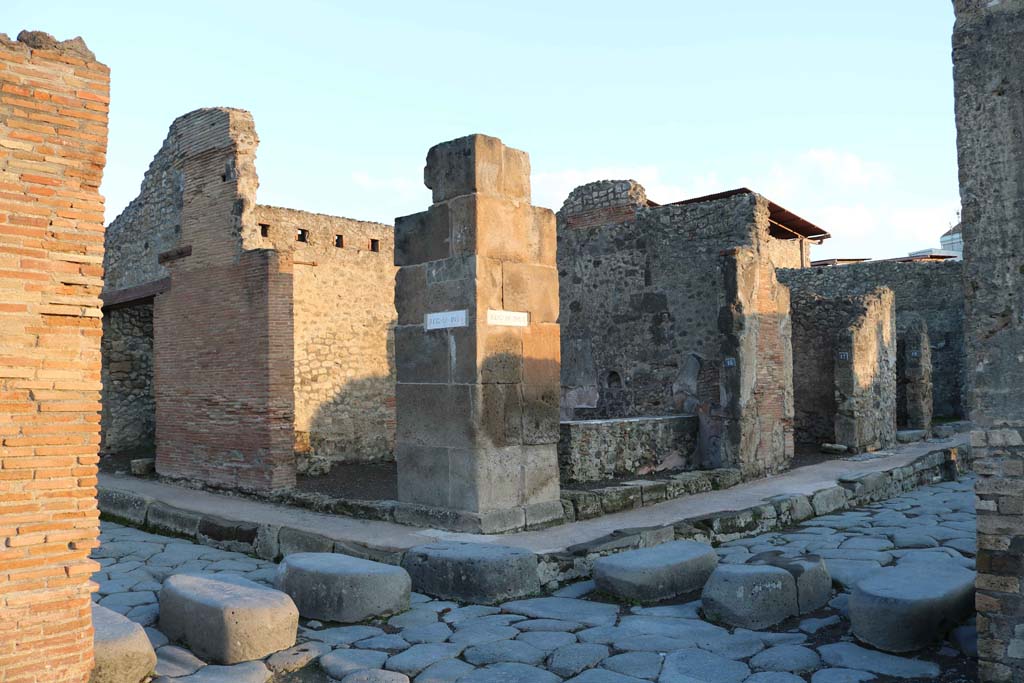 IX.1.15 Pompeii, centre left, and IX.1.16, centre right on Via dell’Abbondanza. December 2018. 
Looking north-east from Holconius’ crossroads, towards bar with two entrances. Photo courtesy of Aude Durand.
