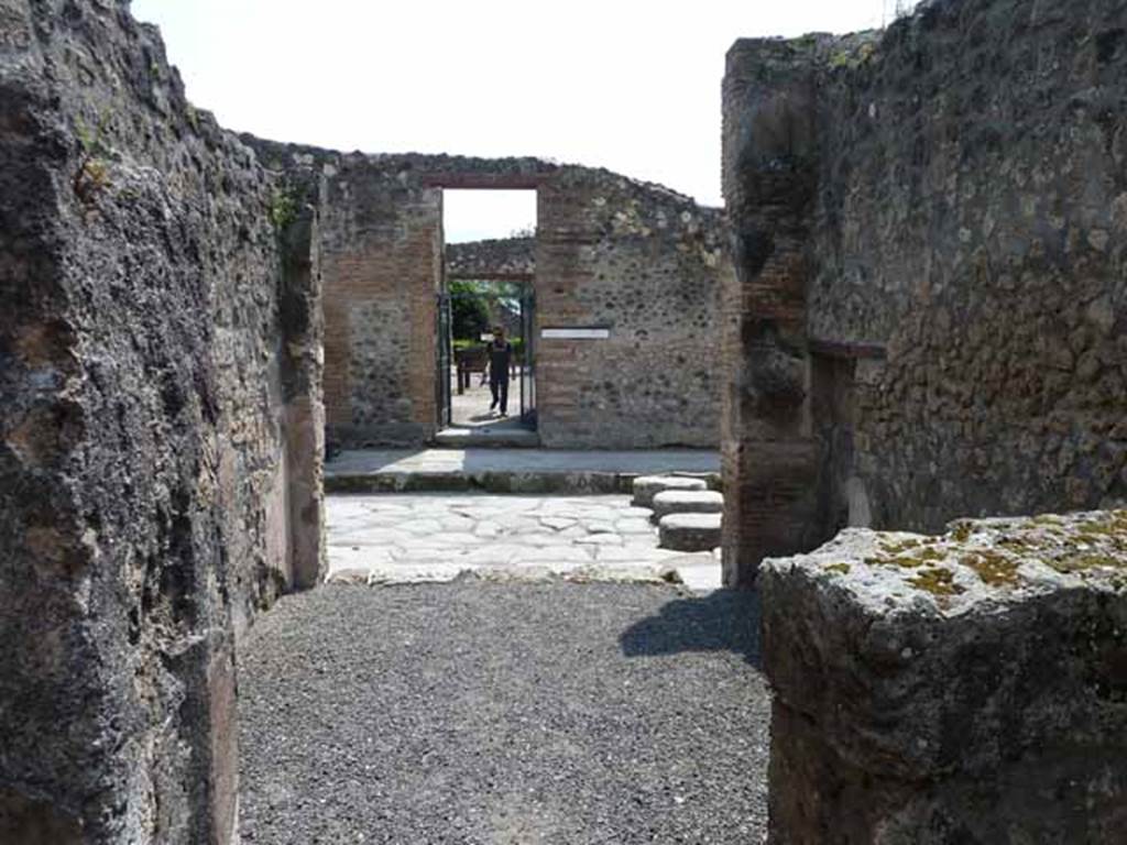 IX.1.24 Pompeii. May 2010. Looking south from doorway of rear room, across front room of shop to Via dell’Abbondanza, and to the doorway of  L. Rapinasi Optati.

