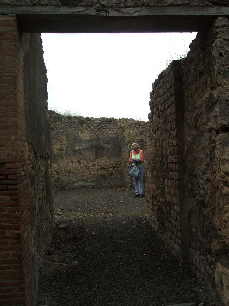 IX.1.32 Pompeii. May 2005. 
Site of steps to upper floor against east wall of atrium. The base of the steps can just be seen in the south-east corner, centre-right.
According to Warscher, “the large white block of tufa seen in the above photo was probably one side of the impluvium of the atrium of IX.1.32”.

