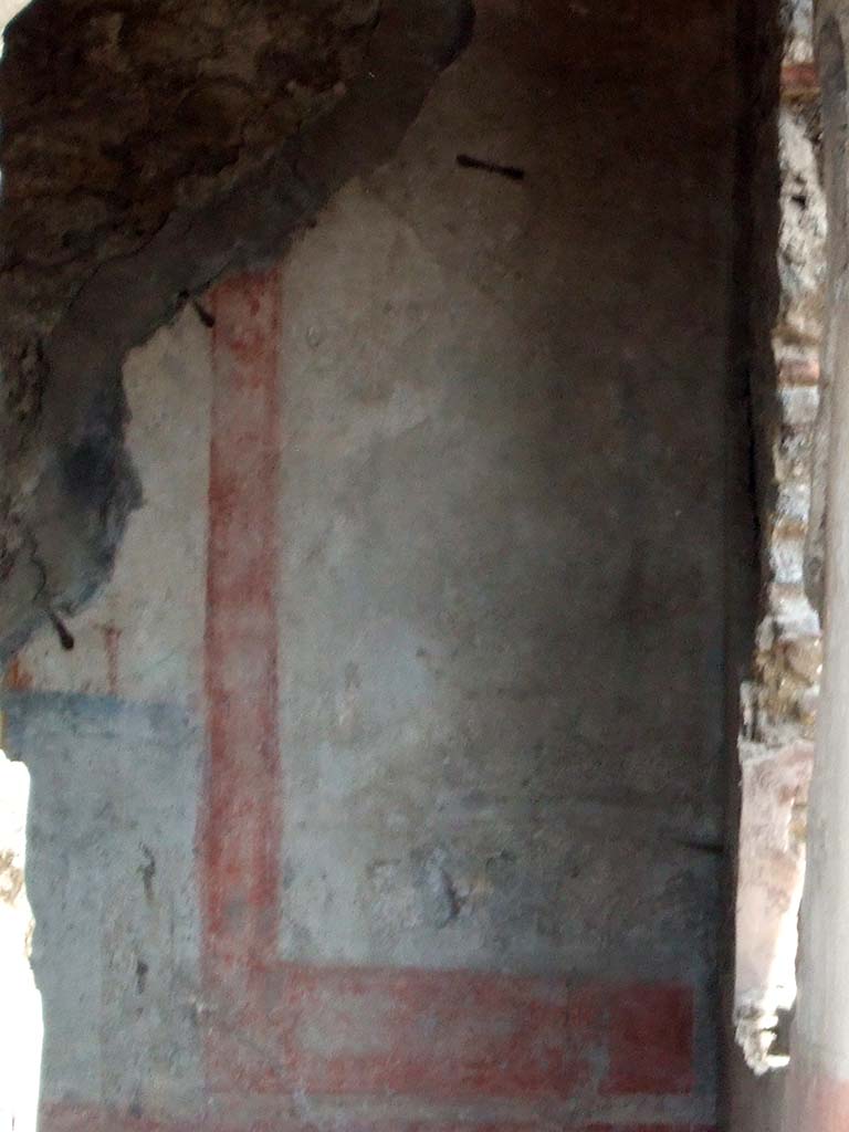 IX.2.7 Pompeii. May 2006.Painted wall in triclinium (k) showing the south end of the east wall.
The red zoccolo showed a panel with oval-leafed plants and compartments with a hanging disc under the separating cornice of the middle zone.
The middle zone presented a white panel, with wide yellow border and a painting of a trophy vase.
The south wall had a window overlooking the garden area.
It was in the centre of the wall between the two white side panels, in which were paintings of trophy vases (13 x 22 - vasi agonistici), now illegible.
The zoccolo was red.
On the west wall, to the north of the doorway, with a yellow central panel and a white predella below it, was a painting with Leda, now illegible. (see Helbig 143).
On the north wall, in the central panel, was a painting of Achilles at Skyros, but preserved only in the upper right corner. (See Helbig 1302).
See Bragantini, de Vos, Badoni, 1986. Pitture e Pavimenti di Pompei, Parte 3. Rome: ICCD. (p.409)
See Helbig, W., 1868. Wandgemälde der vom Vesuv verschütteten Städte Campaniens. Leipzig: Breitkopf und Härtel. (143 and 1302)
