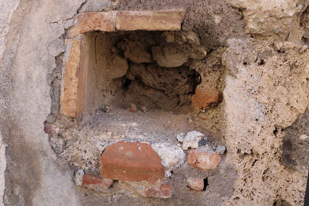 IX.2.21 Pompeii. December 2018. 
West side of entrance doorway, possible niche, or as described by Warscher “a hole for barring the door”. Photo courtesy of Aude Durand.

