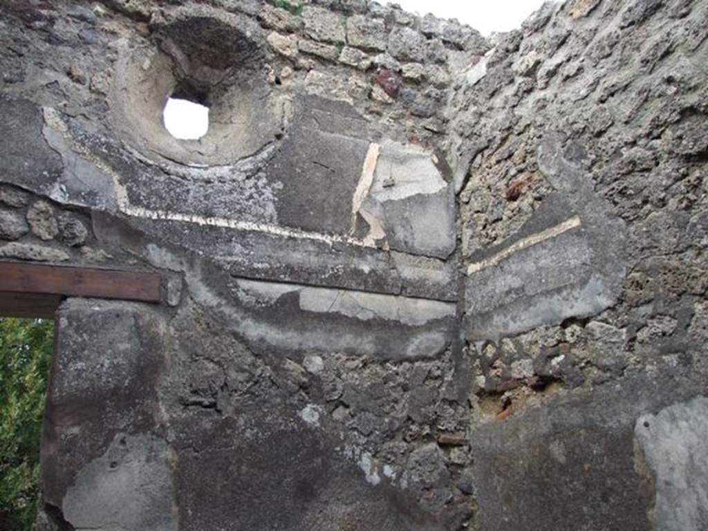 IX.3.15 Pompeii. March 2009. Room 9, north wall with door leading onto the peristyle, and small circular window above the remains of the cornice. A blocked door is in the east wall, at its north end (on right of picture).


