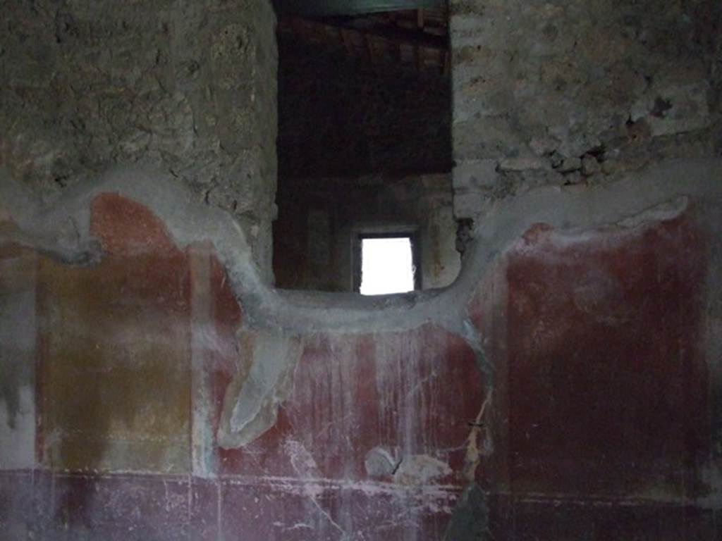 IX.3.19 Pompeii. December 2007. Room 12, north wall of triclinium, with window into oecus.
The making of the window interrupted the symmetrical structure of the IV style decoration on this wall.  This wall had a violet/purple zoccolo which was divided into panels and narrow compartments, which continued up onto the middle zone, painted with candelabra. In the middle of the wall was a red aedicula with a central painting, but only traces of the lower framework was still visible. The side panels were yellow, and at their extremity were black panels, but now totally faded and appearing white. In each of these side panels, was a medallion, also now faded, but the outline could be seen.
See Carratelli, G. P., 1990-2003. Pompei: Pitture e Mosaici: Vol. IX. Roma: Istituto della enciclopedia italiana, (p.350)

