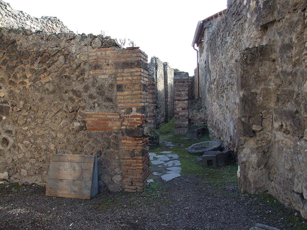 IX.5.4 Pompeii. December 2007. 
Looking south into bakery mills area through doorway in south wall of shop-room.

