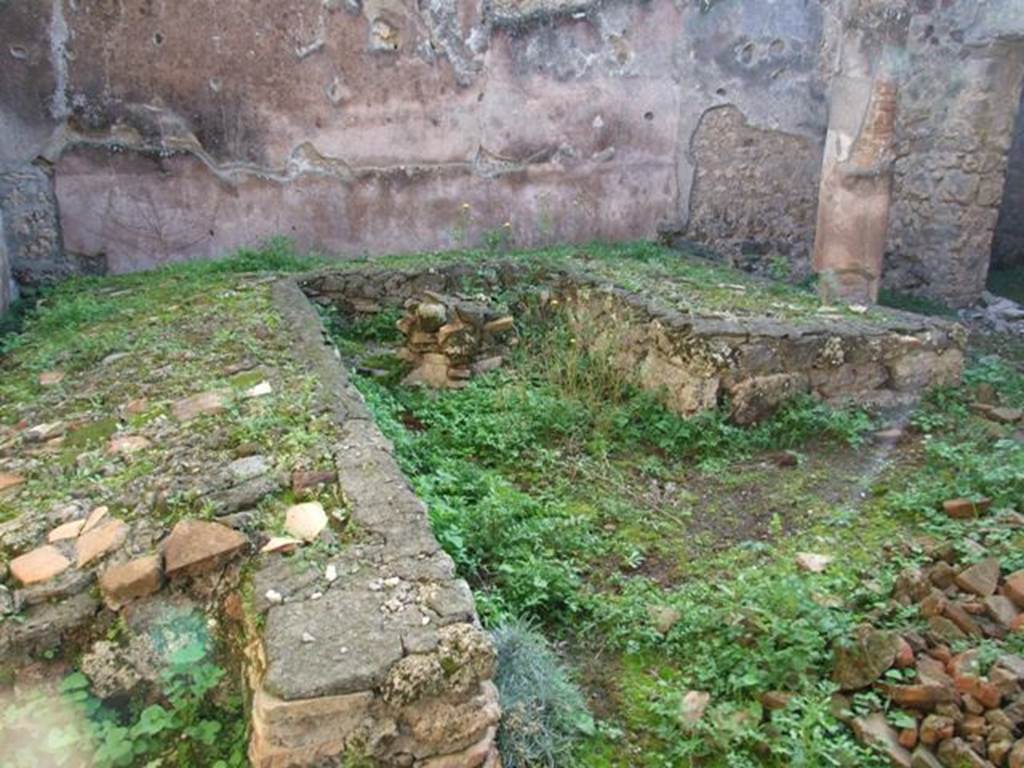 IX.5.11 Pompeii. December 2007. Room 15, looking south-west across triclinium in garden area.  According to Soprano –  “Ubicazione: giardino. L. medius, m.410; l. imus, m.3.86; l. summus, m.3.12; diametro della mensa, m.0.90; lunghezza della panca, m.1.05; larghezza della panca, m.0.55.
Bibliog. Thedenat, op. c. p.84, “Bull. Inst”. 1874, p.195, Viola, op. c. p.29; Mau-Kelsey, p.258.
Occupa tutta l’area di un piccolo giardino con, su due lati, un portichetto composto di cinque colonne, tre sul lato meridionale e due sul lato occidentale, e con gli intercolunni chiusi da un basso pluteo.
Nessuno dei tre letti, a piano inclinato, era addossato a muri.  La mensa, circolare, ha intorno alla base sei nicchiette absidate. Sul  prolungamento del l. imus v’era una piccola panca rettangolare che era poco piu basso dei tre letti; serviva per sgabello ai bambini che dovevano consumare i pasti stando seduti e non sdraiati. Sotto questo podio c’era una nicchietta rettangolare, e a destra una vaschetta quadrata formata con grosse pietra vesuviane. Davanti al l. summus, infine, era situata una base a sezione quadrata, Le pareti del giardino sono rivestite d’intonaco rosso, e lungo le pareti verticali del l. imus si nota qualche traccia di intonaco d’incerta colore.
See Soprano, P. (1950). I triclini all’aperto di Pompei. (In Pompeiana, raccolta di studi per il secondo centenario degli scavi di Pompei. Napoli, Gaetano Macchiaroli, Editore, P. 302-3, no.19).



