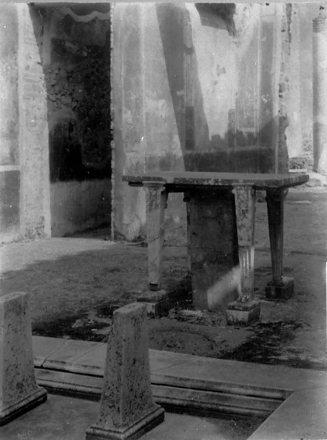 X.5.11 Pompeii. 1931. Room 1, marble table or cartibulum behind impluvium in atrium. At the rear on the left, is the corridor and the east wall of tablinum.
DAIR 31.2857. Photo © Deutsches Archäologisches Institut, Abteilung Rom, Arkiv. 
See http://arachne.uni-koeln.de/item/marbilderbestand/936484

