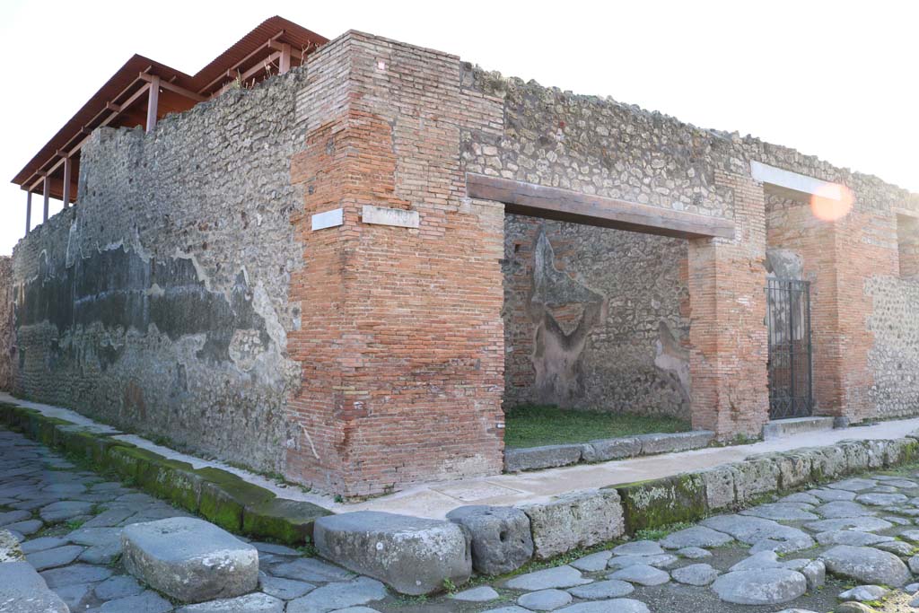 IX.5.12 Pompeii. December 2018. 
Looking south-west towards doorway to shop, from junction between Vicolo del Centenario, on left, and Via di Nola, on right.
Photo courtesy of Aude Durand.
