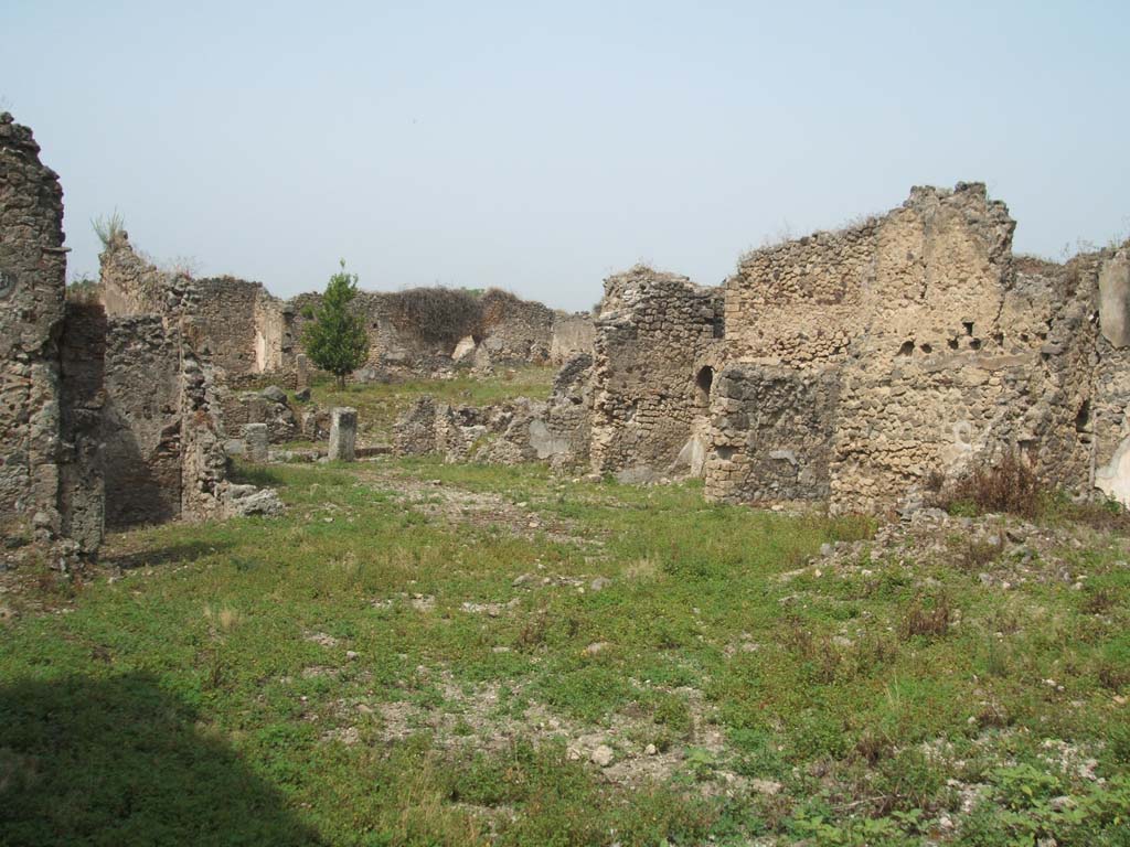 IX.6.4 and IX.6.g Pompeii. May 2005. 
Looking north-west from approximate site of peristyle of IX.6.g, across site of kitchen, garden, and rooms to north of atrium of IX.6.4.
On the right of the photo would have been north-west corner of peristyle of IX.6.g, and then the kitchen, and then rooms “z” and “y”.
