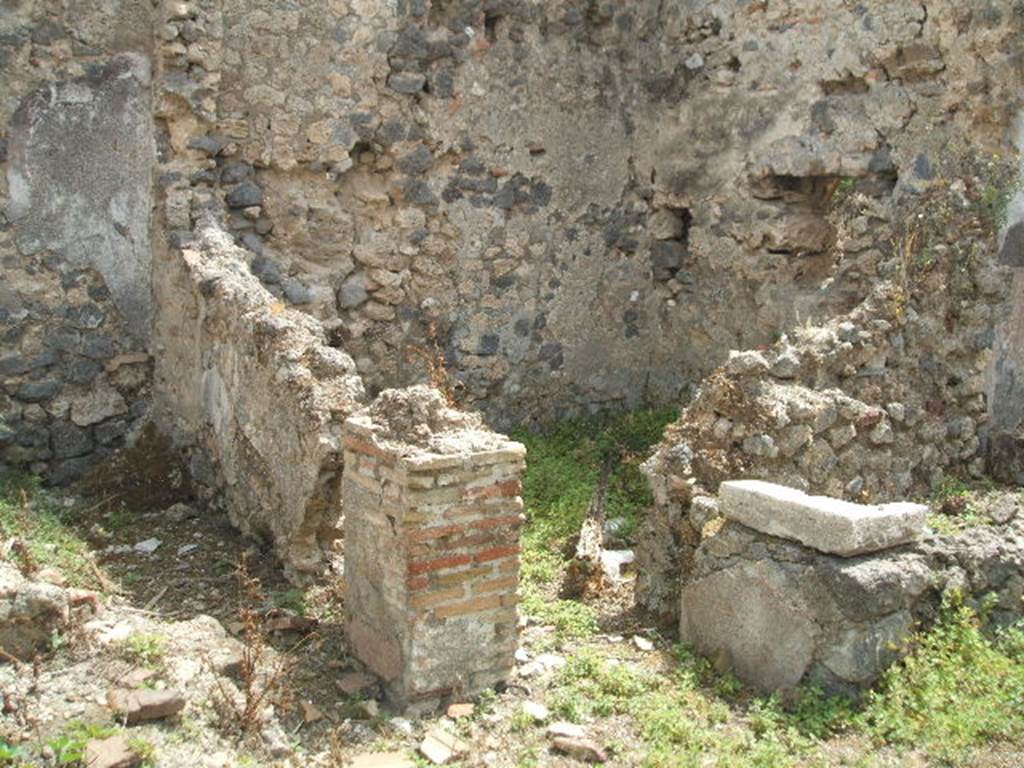 IX.6.7 Pompeii. May 2005. Looking south-east to two rooms on east side of entrance.
These would have been a latrine room “q” on left, and small room or storeroom room “r”, on right. The remains of the tub/basin can be seen on the right of the photo.

