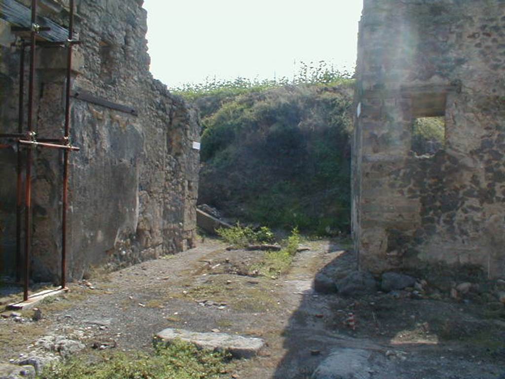IX.8 Pompeii on left.       End of Vicolo del Centenario, looking south (into the unexcavated).        Corner of IX.6.8, on right.
