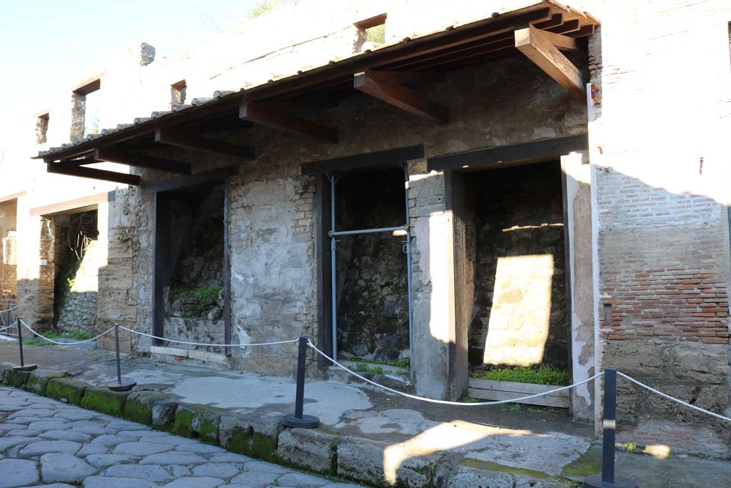 IX.7.8 Pompeii, on left. December 2018. 
Looking west along north side of Via dell’Abbondanza, with IX.7.7 to 5, centre and right. Photo courtesy of Aude Durand.

