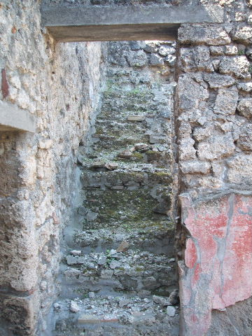 IX.7.20 Pompeii. May 2005. Room (n), stone staircase to upper floor, looking west.