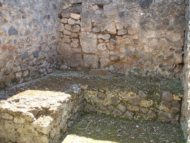 IX.7.20 Pompeii. May 2005. Kitchen room (p) L-shaped two-sided stone hearth or bench, against east and south wall.
